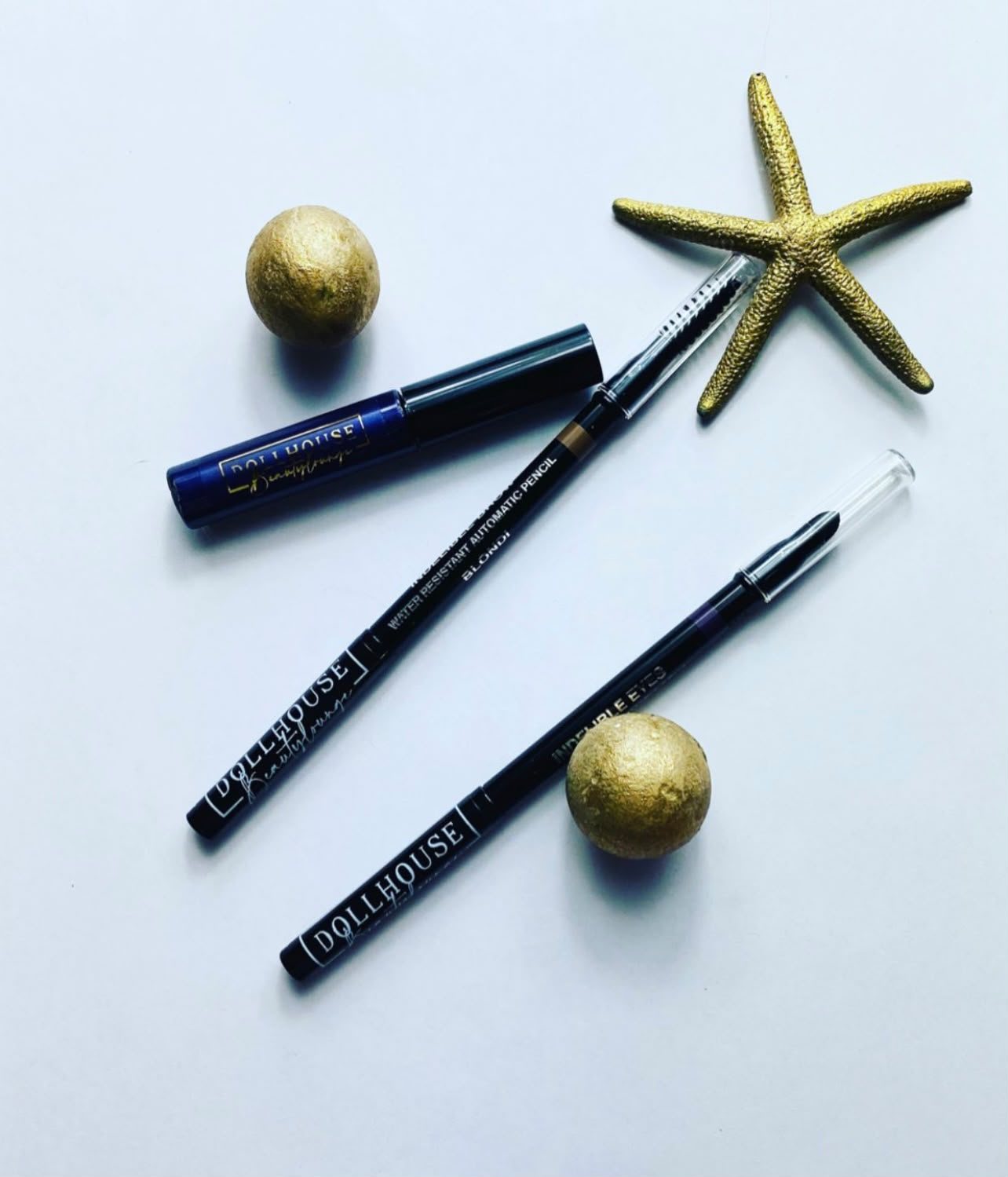 Dollhouse eye cosmetics: mascara and eyeliners with a starfish and gold accents